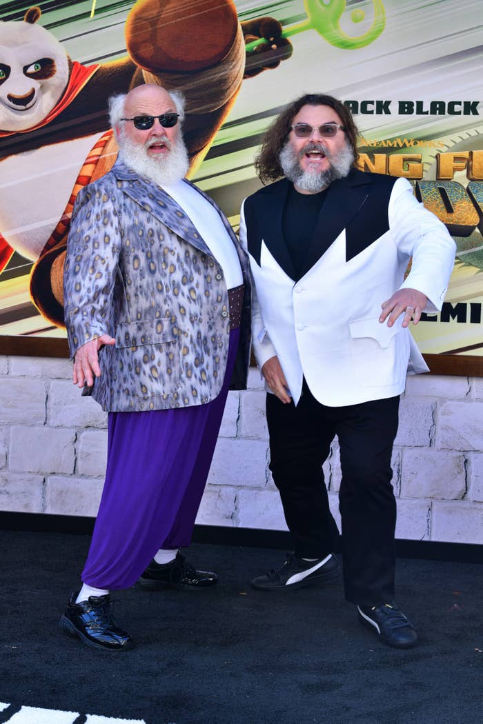 Jack Black and another person smiling and posing playfully in front of a "Kung Fu Panda" promotional banner