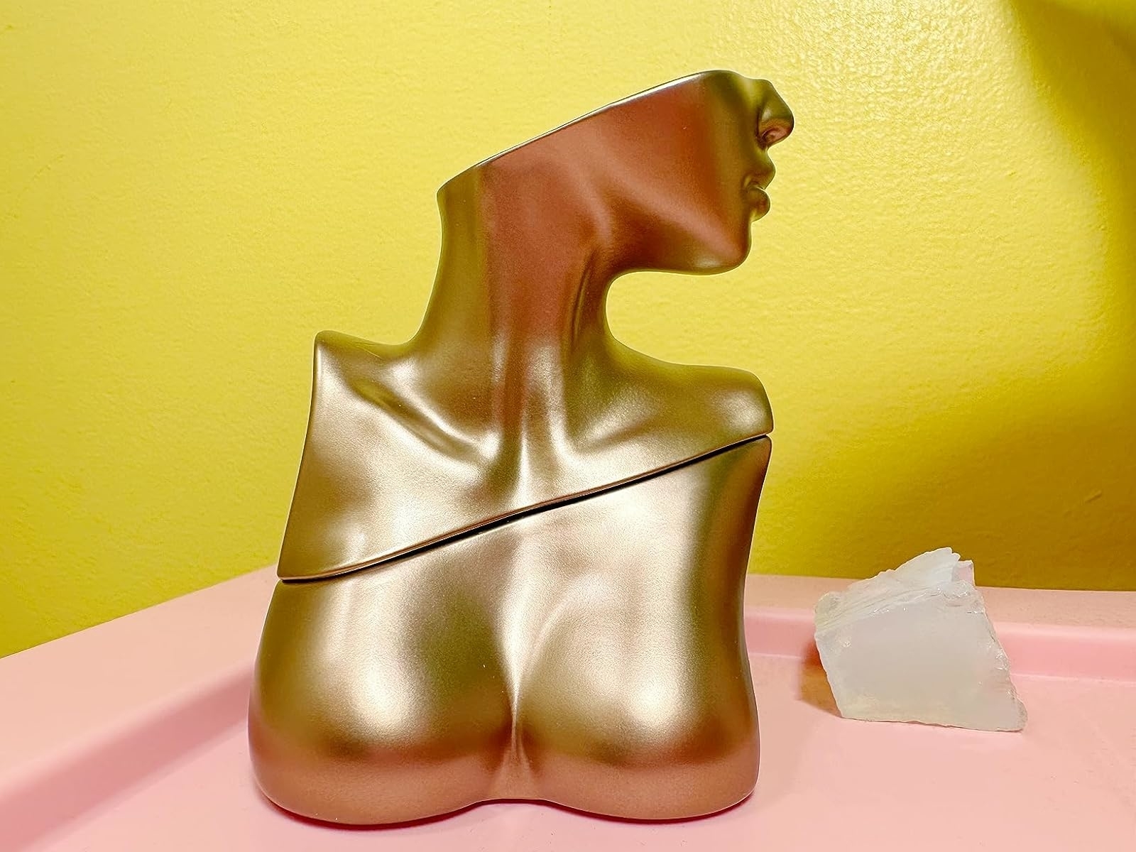 reviewer's gold torso-shaped perfume bottle