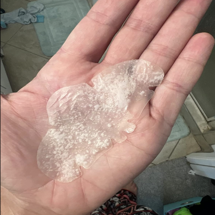 A hand holding a translucent, butterfly-shaped skincare mask, indicating it is an article about beauty products or shopping for skincare items