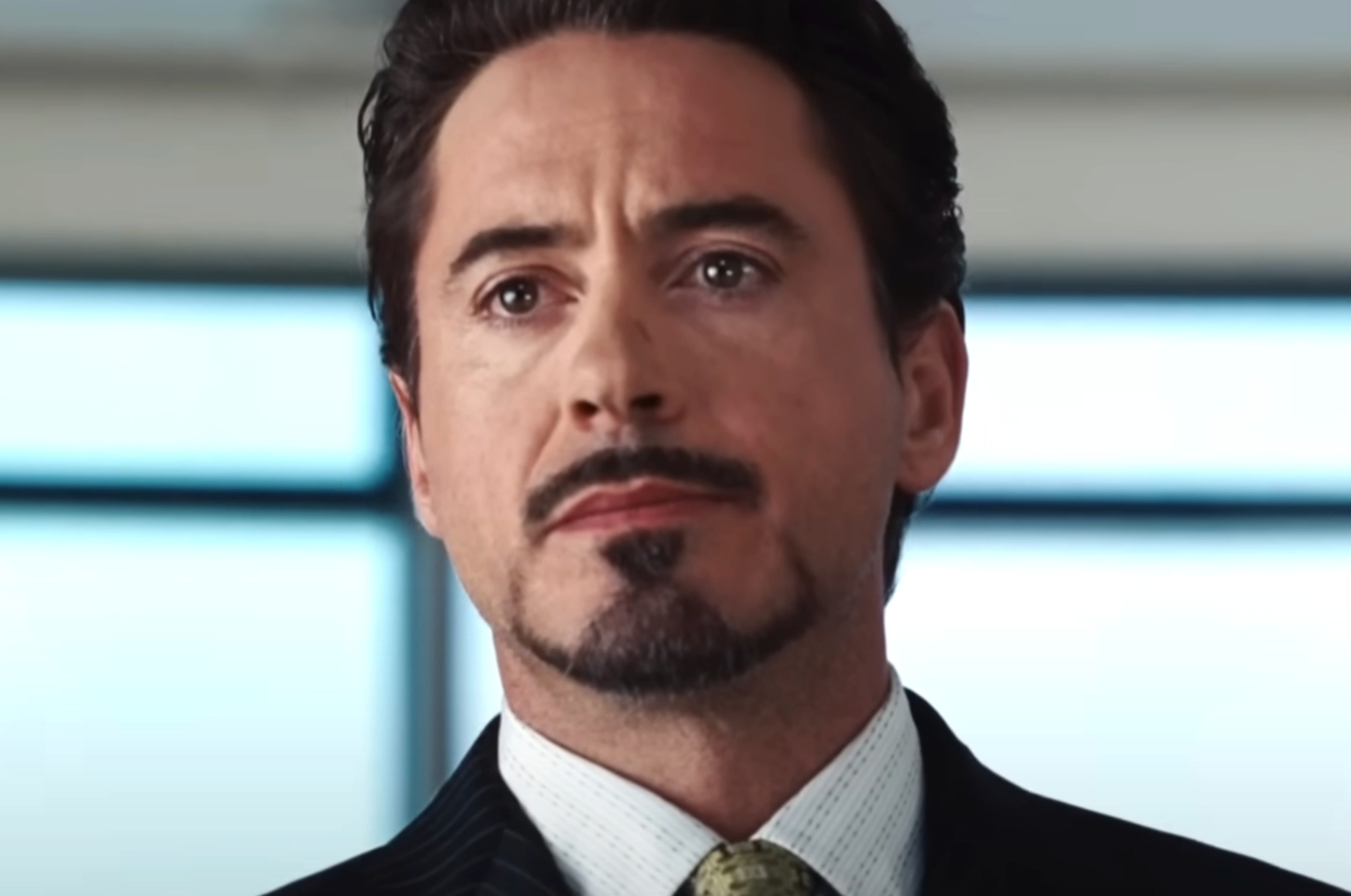 Robert Downey Jr. in a movie scene, wearing a suit and tie, with a serious expression