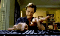 A person types frantically on a computer keyboard in a comedic manner, portraying intense focus and urgency