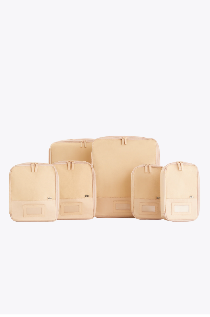 six travel packing cubes of varying sizes are arranged in a group