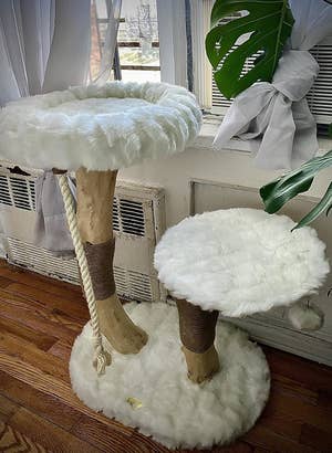 Plush cat tree with two platforms, one higher and larger than the other, featuring faux fur surfaces and a rope for climbing