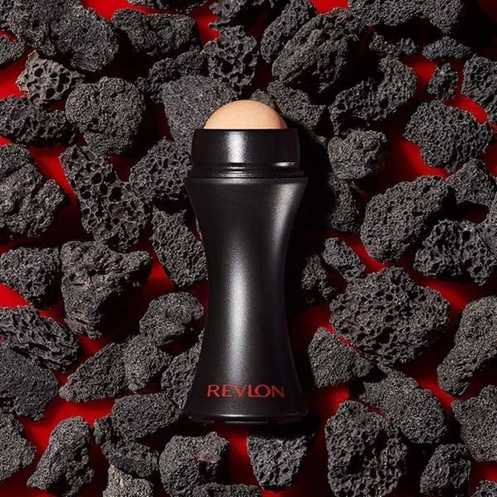 Revlon volcanic stone face roller on a bed of volcanic rocks, featured in a shopping article