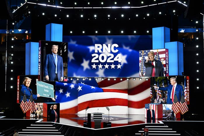 Stage setup for the RNC 2024 featuring multiple images of Donald Trump, with an American flag backdrop and podium