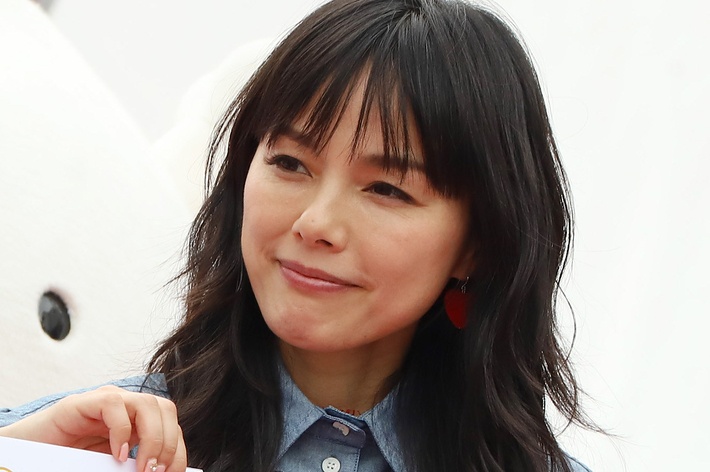 女性が赤いハート型のデザインが入ったデニムシャツを着て、特別イベントに出席しています。