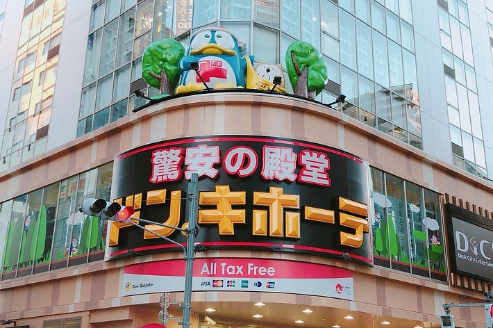 ドン・キホーテ店舗の外観、建物中央に大きな看板とマスコットキャラクターが描かれている。