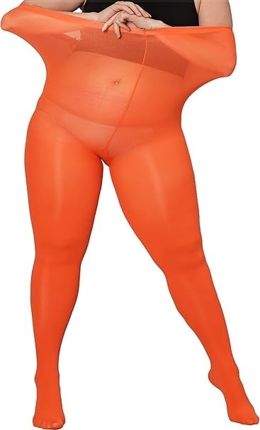 Person demonstrates the elasticity of orangish  pantyhose by stretching the waistband. The person’s look   is not visible