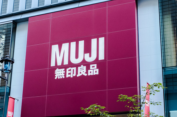 無印良品の店舗の外観。店舗の大きな看板に「MUJI 無印良品」と書かれています。