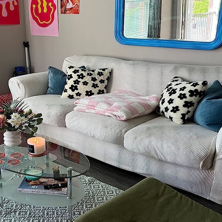 the pink checkerboard blanket folded up on a couch