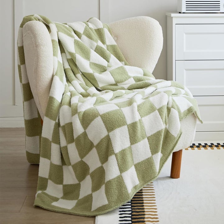 A plush chair draped with a checkered throw blanket, adding a cozy touch to a stylish room setup