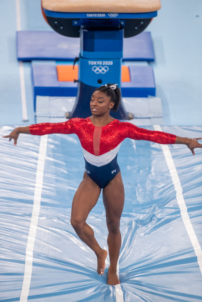 Simone Biles performing a gymnastics routine at the Tokyo 2020 Olympics wearing a long-sleeved leotard