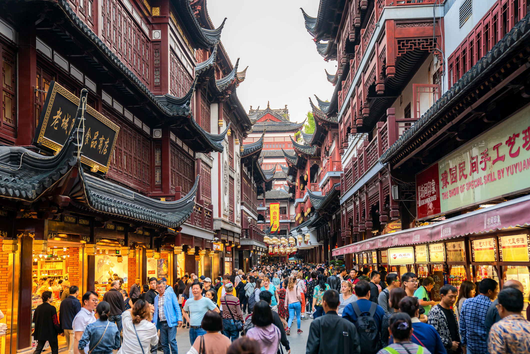 A bustling street in Shanghai's Old City, filled with people shopping and exploring traditional Chinese architecture and shops