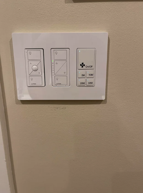 A wall-mounted control panel with buttons for lighting and fan settings, including options for 5, 10, 20, and 30 minutes