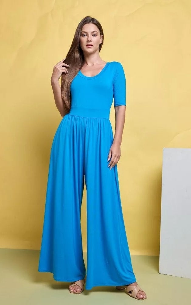 A model wearing a knit blue jumpsuit and sandals