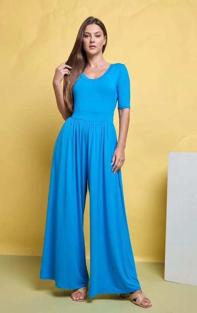 A model wearing a knit blue jumpsuit and sandals
