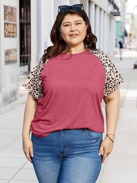 Plus-size exemplary successful casual jeans and a T-shirt with printed sleeves, smiling portion lasting outdoors connected a sidewalk