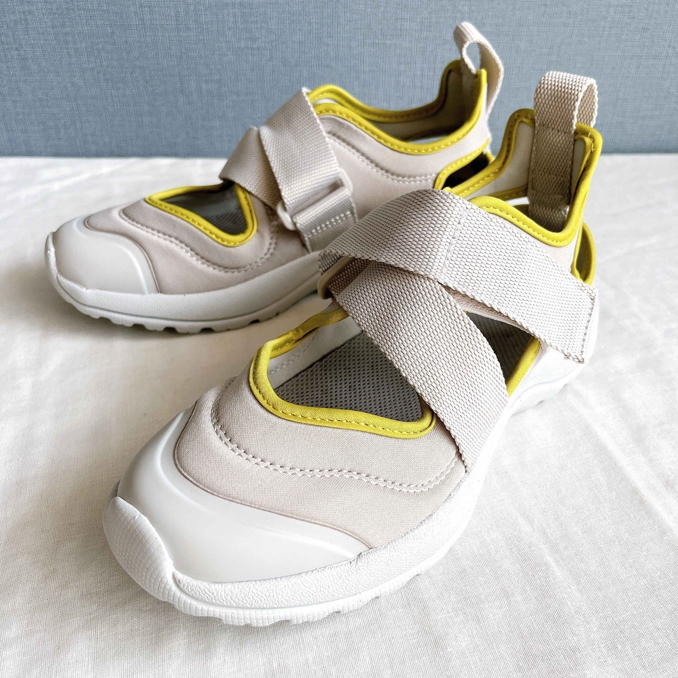 Pair of modern, sporty shoes with thick straps and rubber soles on a white surface