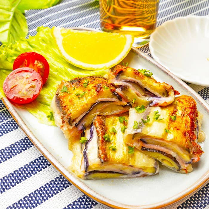 レタスとレモンスライスが添えられた焼きナスとチーズの料理が皿に盛り付けられています。