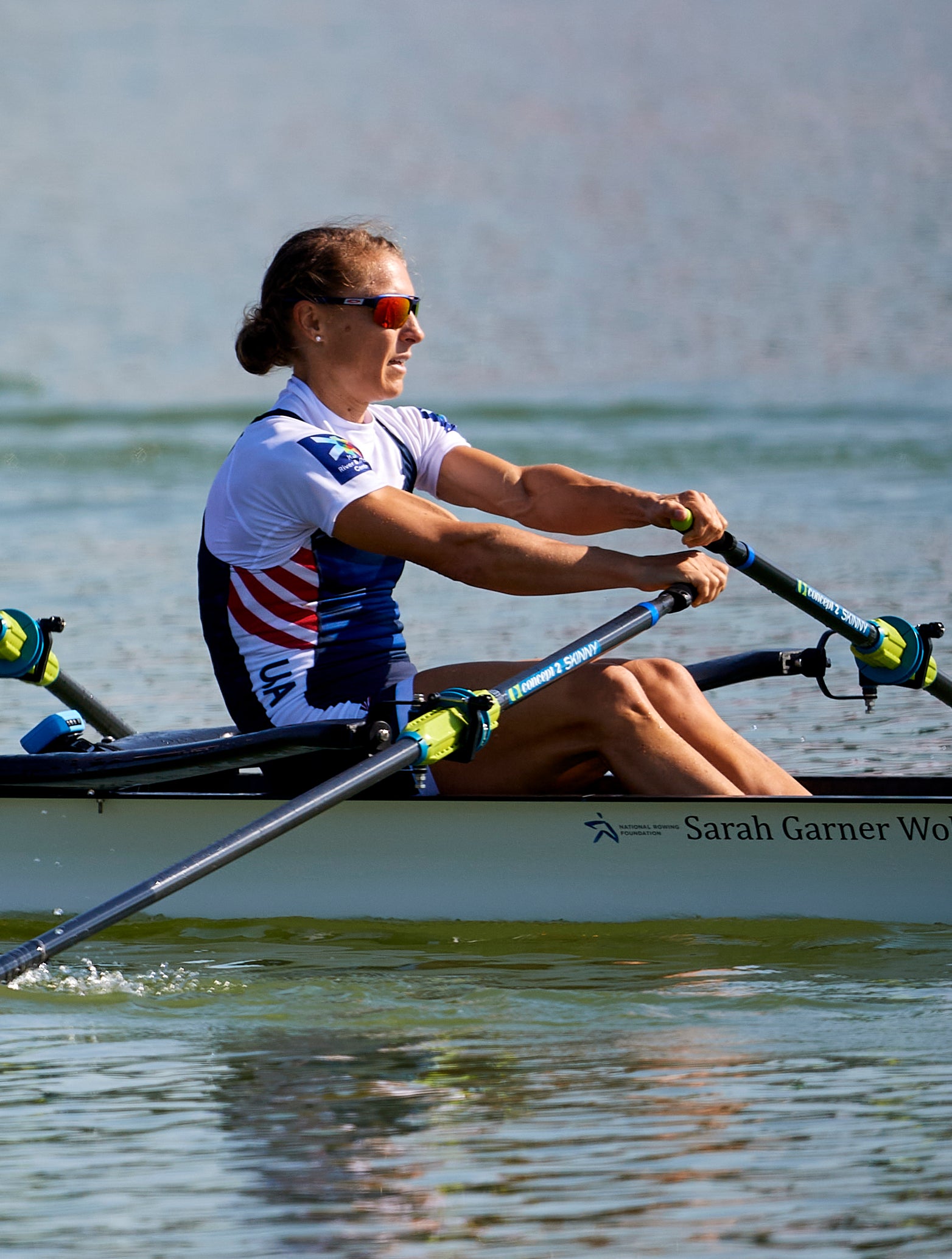 Michelle rowing a canoe, wearing uniform and sunglasses with hair in bun