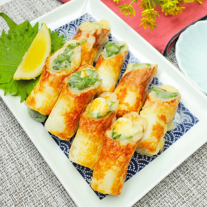 お皿に盛られた練り物の揚げ巻き、レモンのスライスと大葉が添えられている。