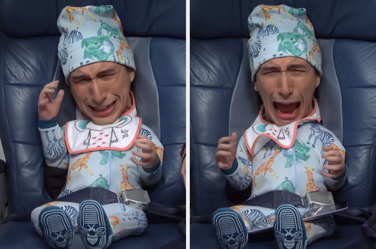 Adam Driver is dressed as a crying baby in an airplane seat, wearing baby blue patterned pajamas and a matching hat