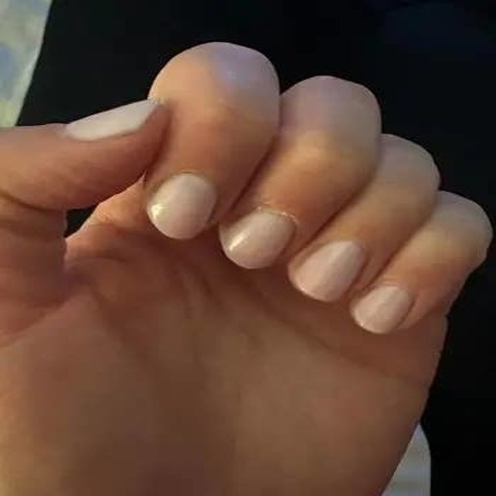 Close-up view of a person's hand with neatly manicured nails painted with a light shade