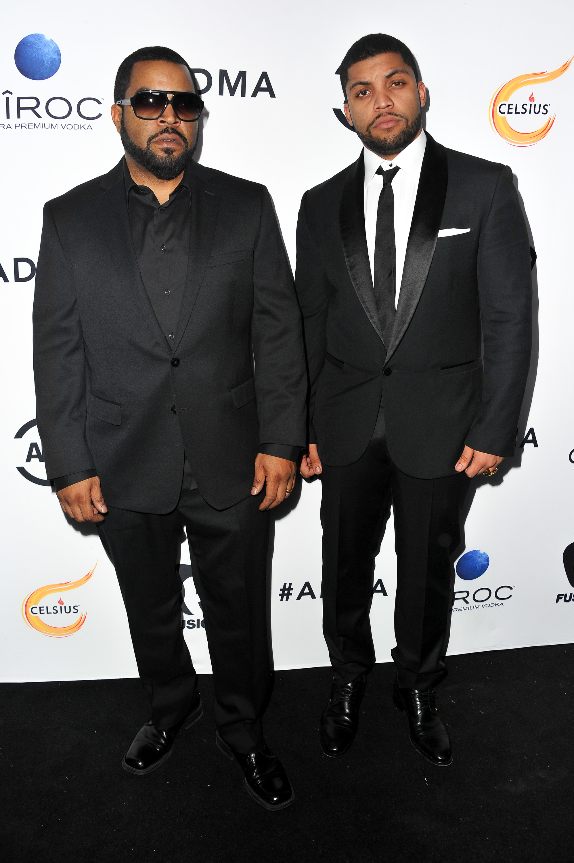 Ice Cube and O'Shea Jackson Jr. on the red carpet, both wearing black suits with white shirts and black ties