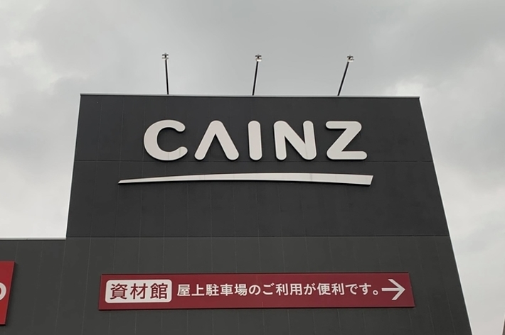 ホームセンター「カインズ」の外観。店舗入り口上部に「資材館 上屋駐車場のご利用が便利です→」と表示。