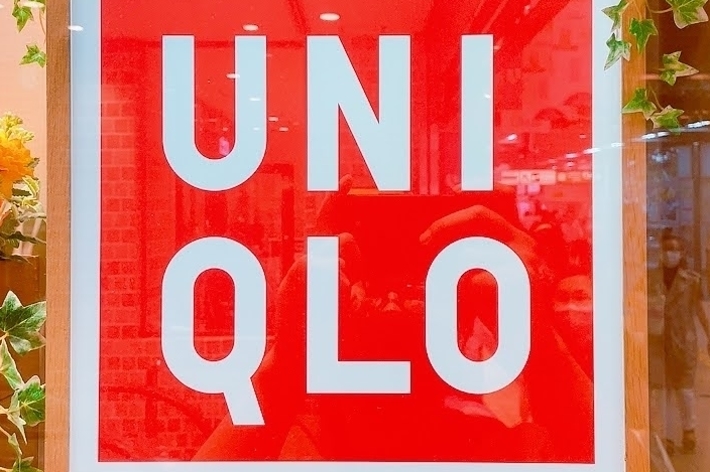 UNI QLO store sign with decorative greenery around it