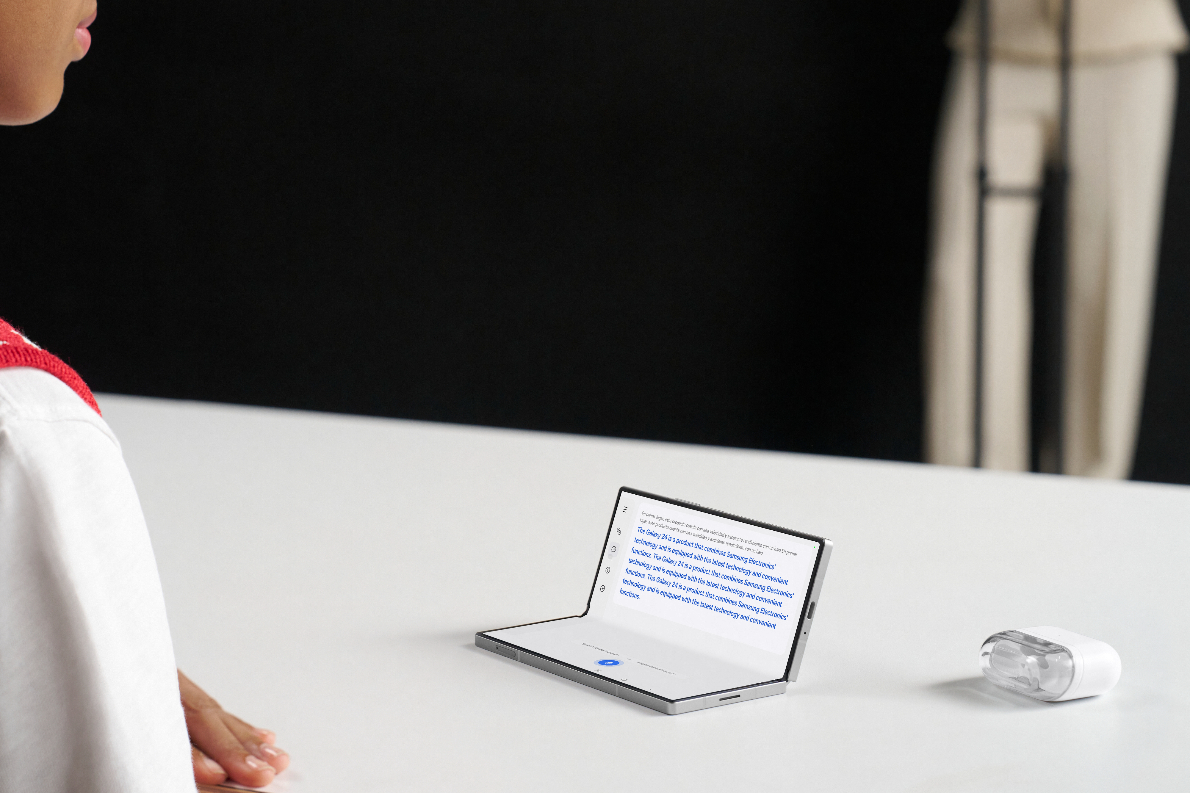 Person sits at a white table looking at a tablet with a screen divided into two parts. A mouse is next to the tablet