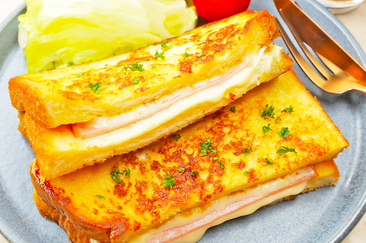 サンドイッチの中身がとろけるチーズとハムが入ったクロックムッシュ、レタスとミニトマトが添えられています。