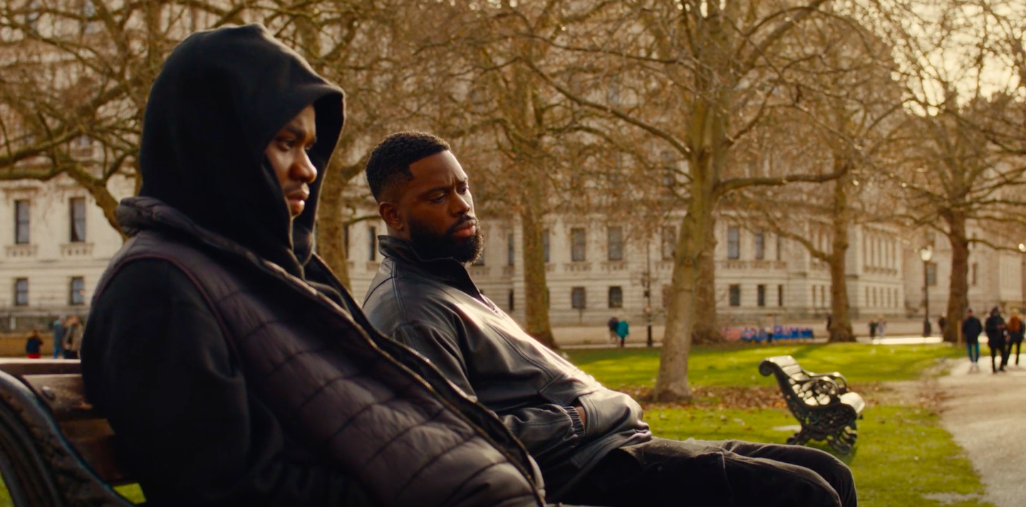 Tazer (Josh Tedeku) and Krazy (Ghetts) meet in a park after Krazy shoots one of Tazer's friends.