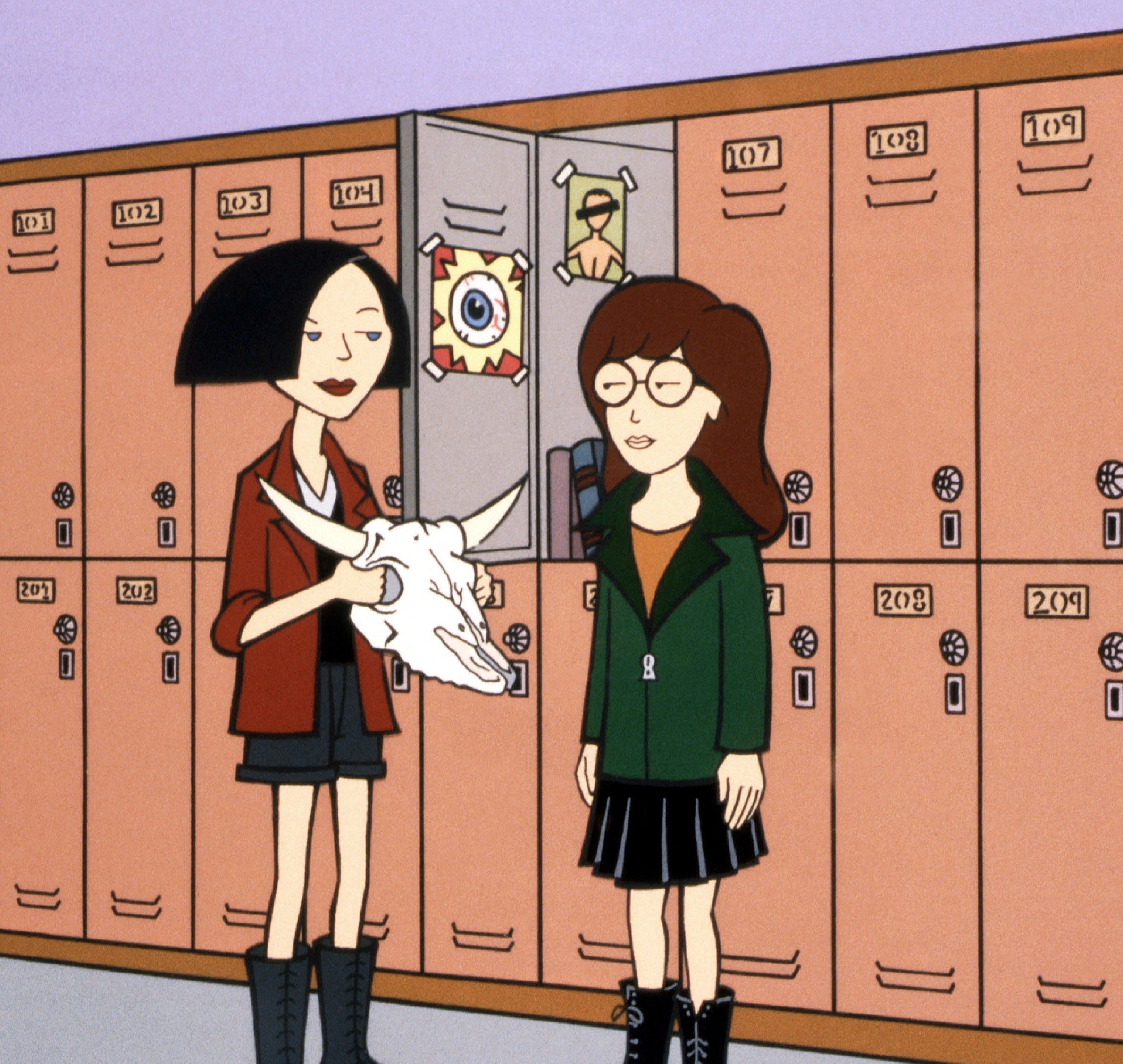 Jane Lane and Daria Morgendorffer stand by school lockers, with Jane holding a paper mache skull. The lockers in the background have various drawings