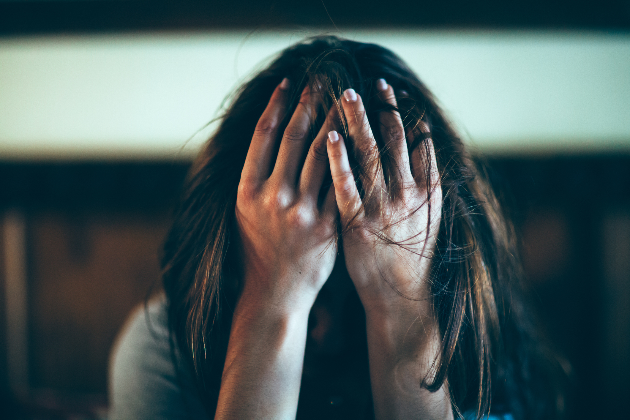 Person with their head in hands, fingers spread through their hair, expressing distress or frustration. No other identifiable features or context visible