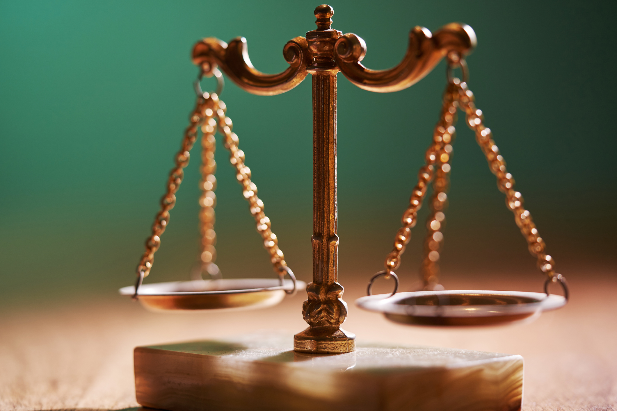 Close-up of a brass balance scale on a wooden surface, symbolizing justice and fairness
