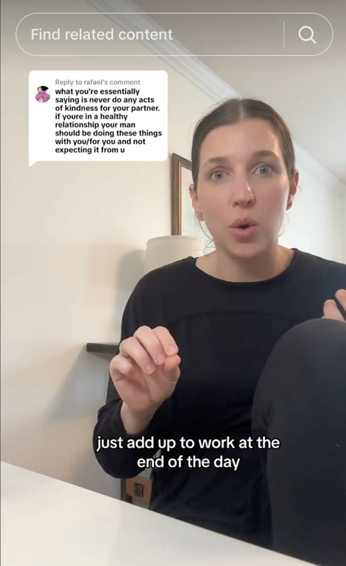 Woman in black top responding to a comment in a video. The comment above reads: "what you're essentially saying is never do any acts of kindness for your partner…" Subtitles read: "just add up to work at the end of the day."