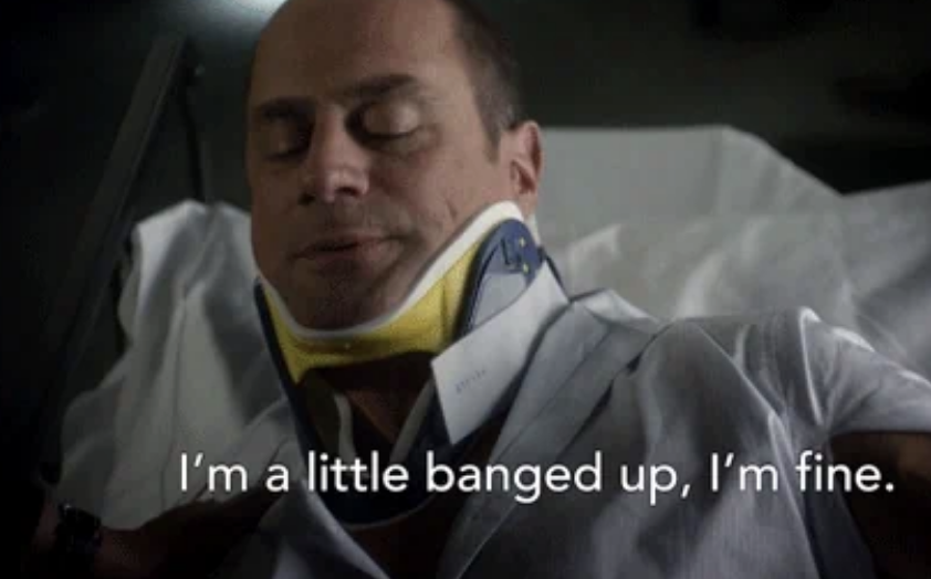 A man lies in a hospital bed wearing a neck brace, with text on the image reading, "I'm a little banged up, I'm fine."