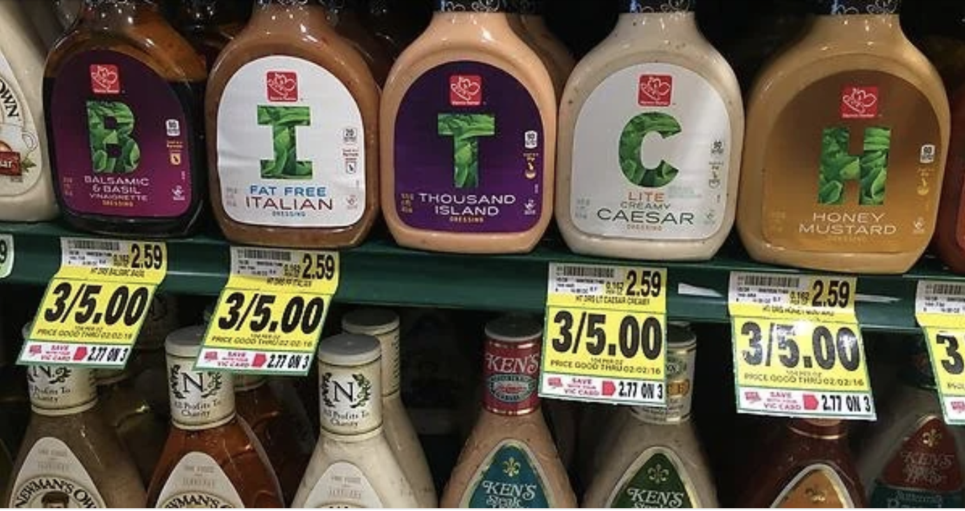 Bottles of salad dressing on a store shelf spell out 'B*ITCH' through their labels. Price tags below show a sale of 3 for $5.00