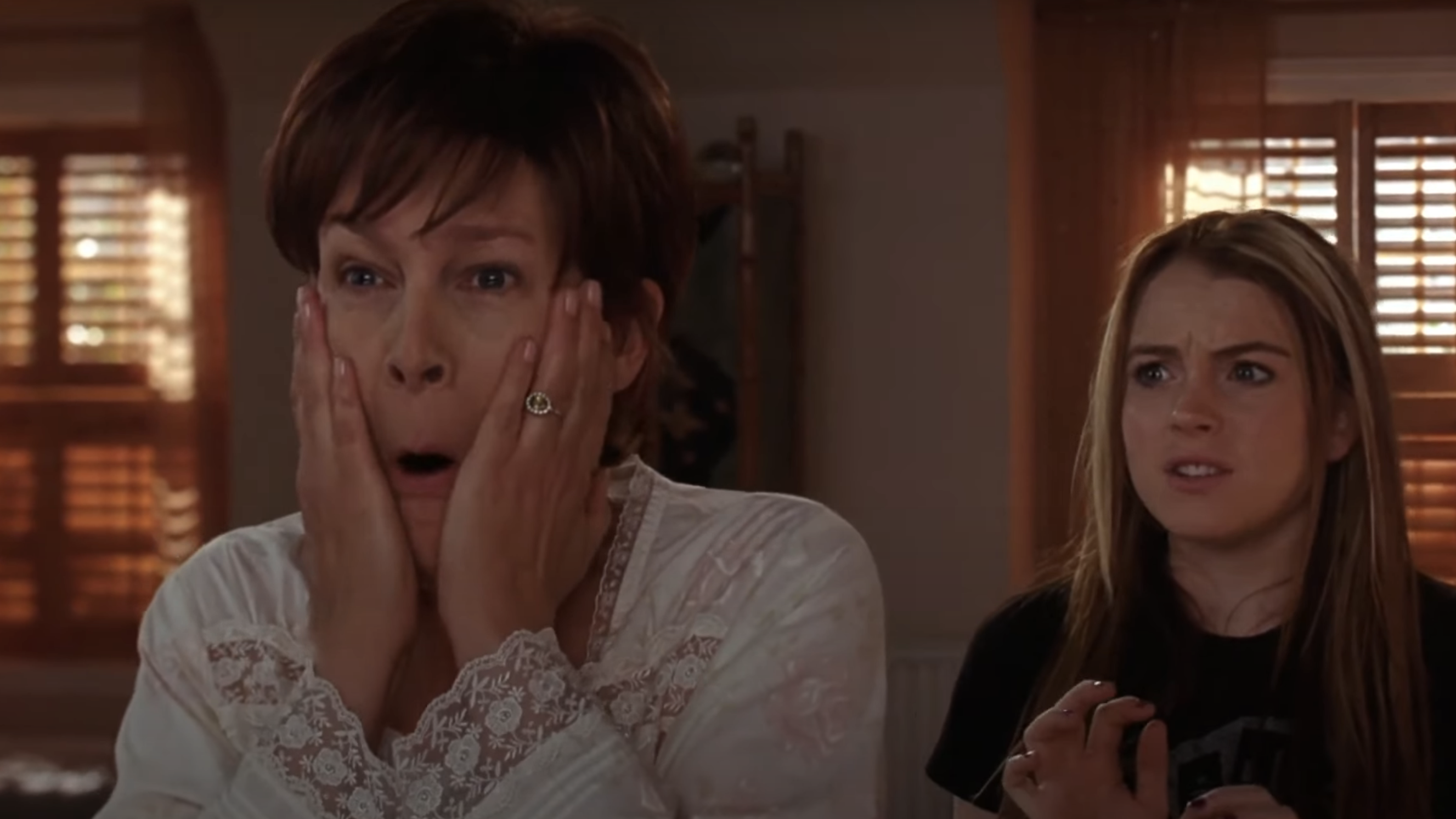 Jamie Lee Curtis holding her face in shock, next to Lindsay Lohan who is looking equally surprised in a scene from "Freaky Friday"