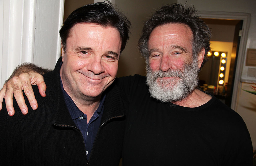 Nathan Lane and Robin Williams smiling and posing together, arms around each other