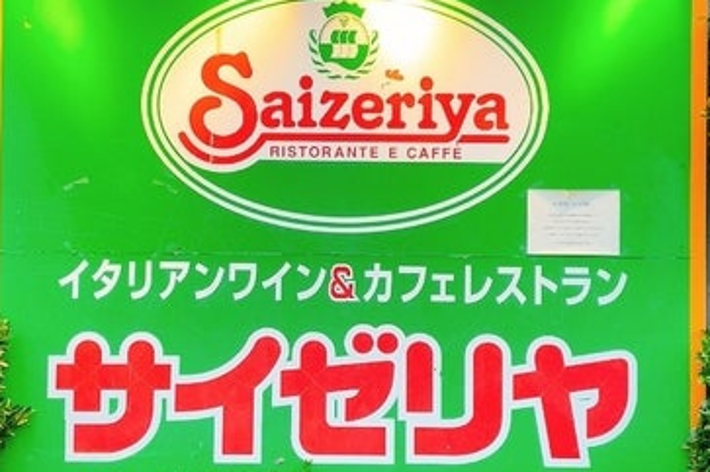 A sign for the Italian restaurant chain Saizeriya, displaying its name in both English and Japanese. Open hours: 11:00 AM - 2:00 AM