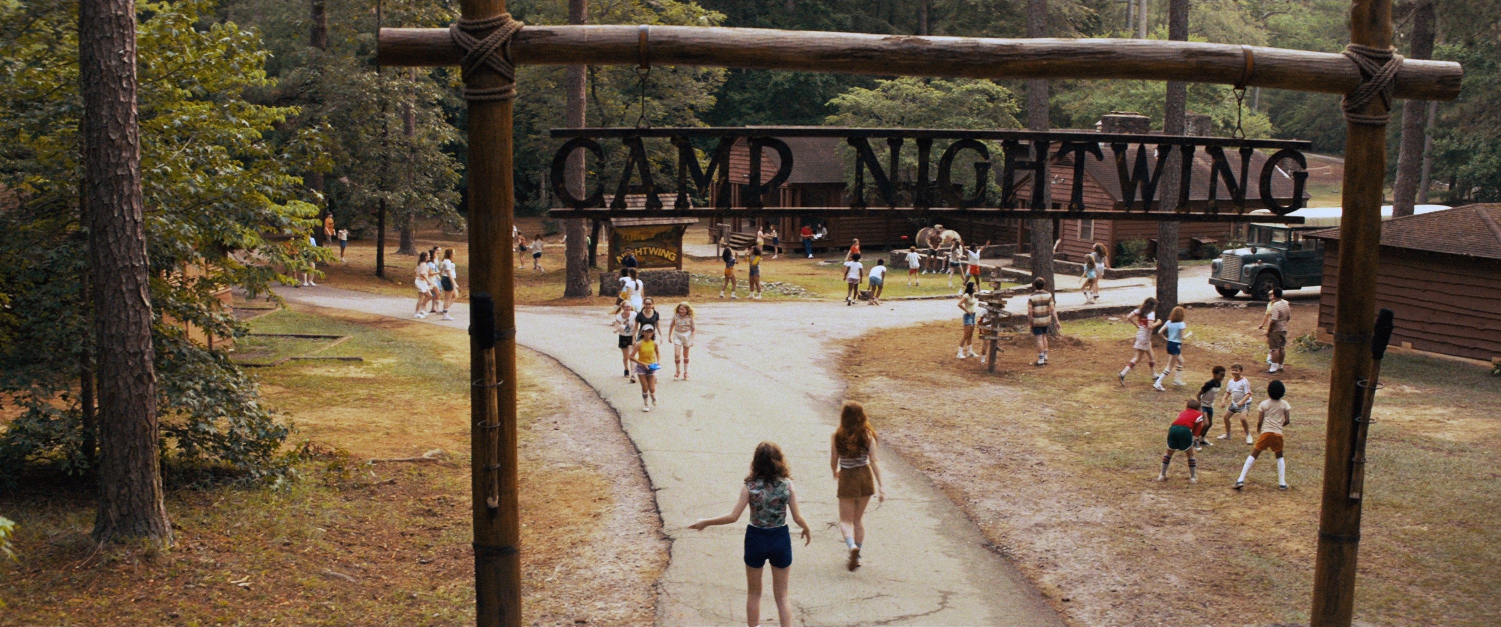 The entrance of Camp Nightwing with a bunch of campers walking in a scene from &quot;Fear Street Part Two: 1978&quot;