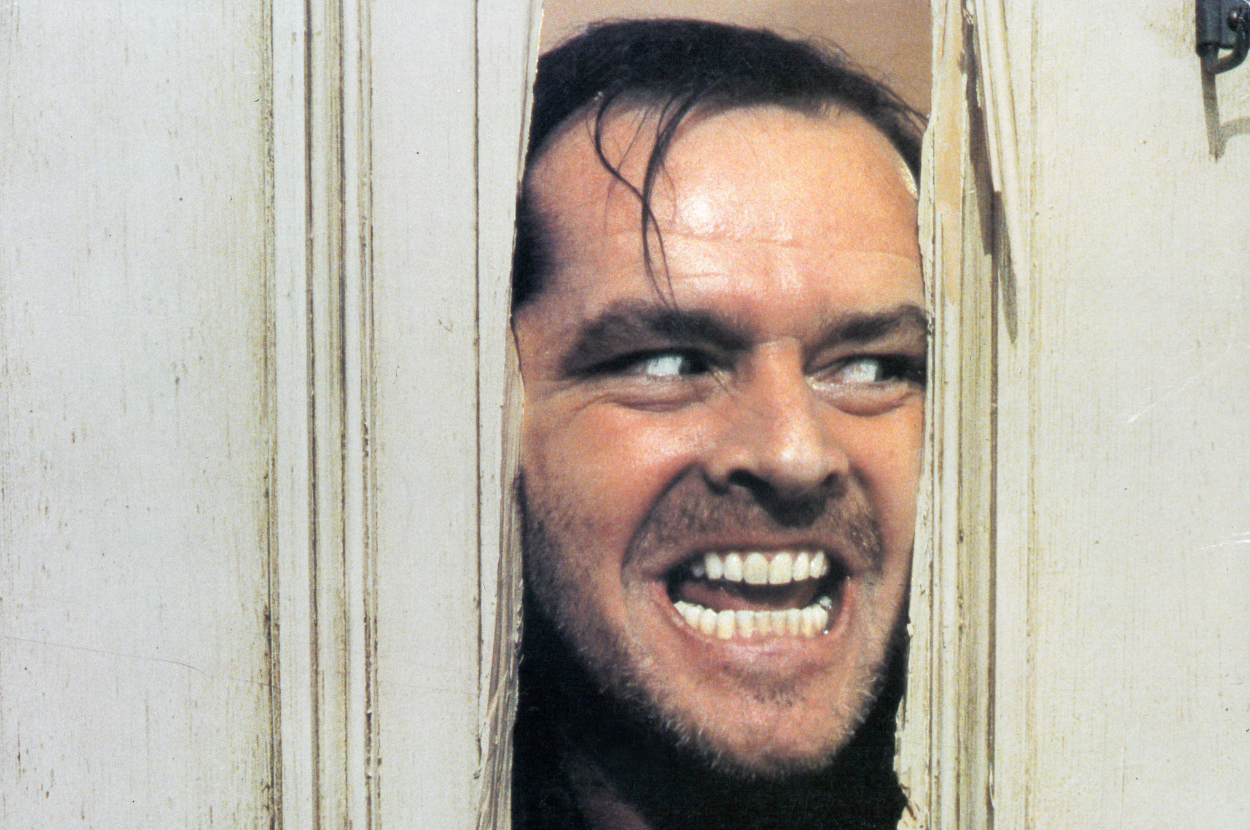 Jack Nicholson's character in 'The Shining' peers through a broken door, grinning maniacally