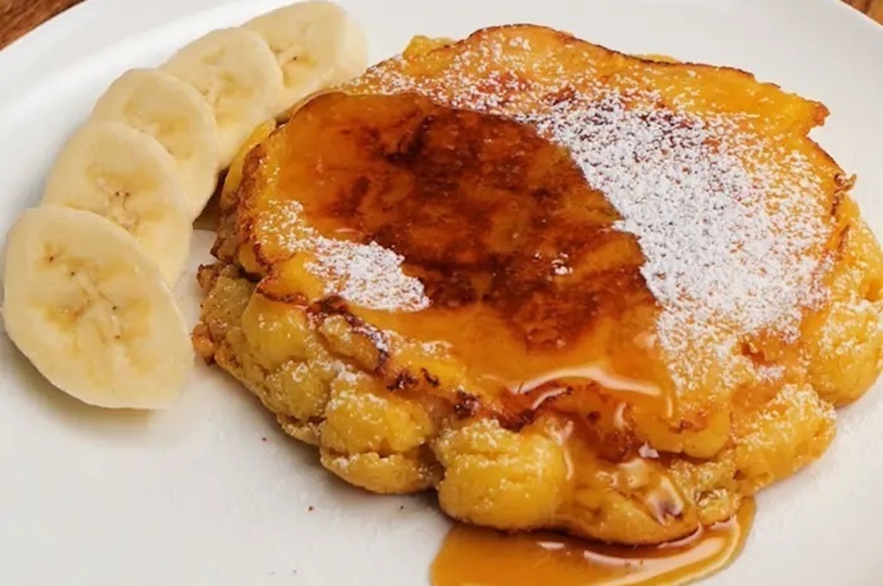 バナナのスライスを添えたキャラメルアップルパンケーキが白い皿に盛られています。