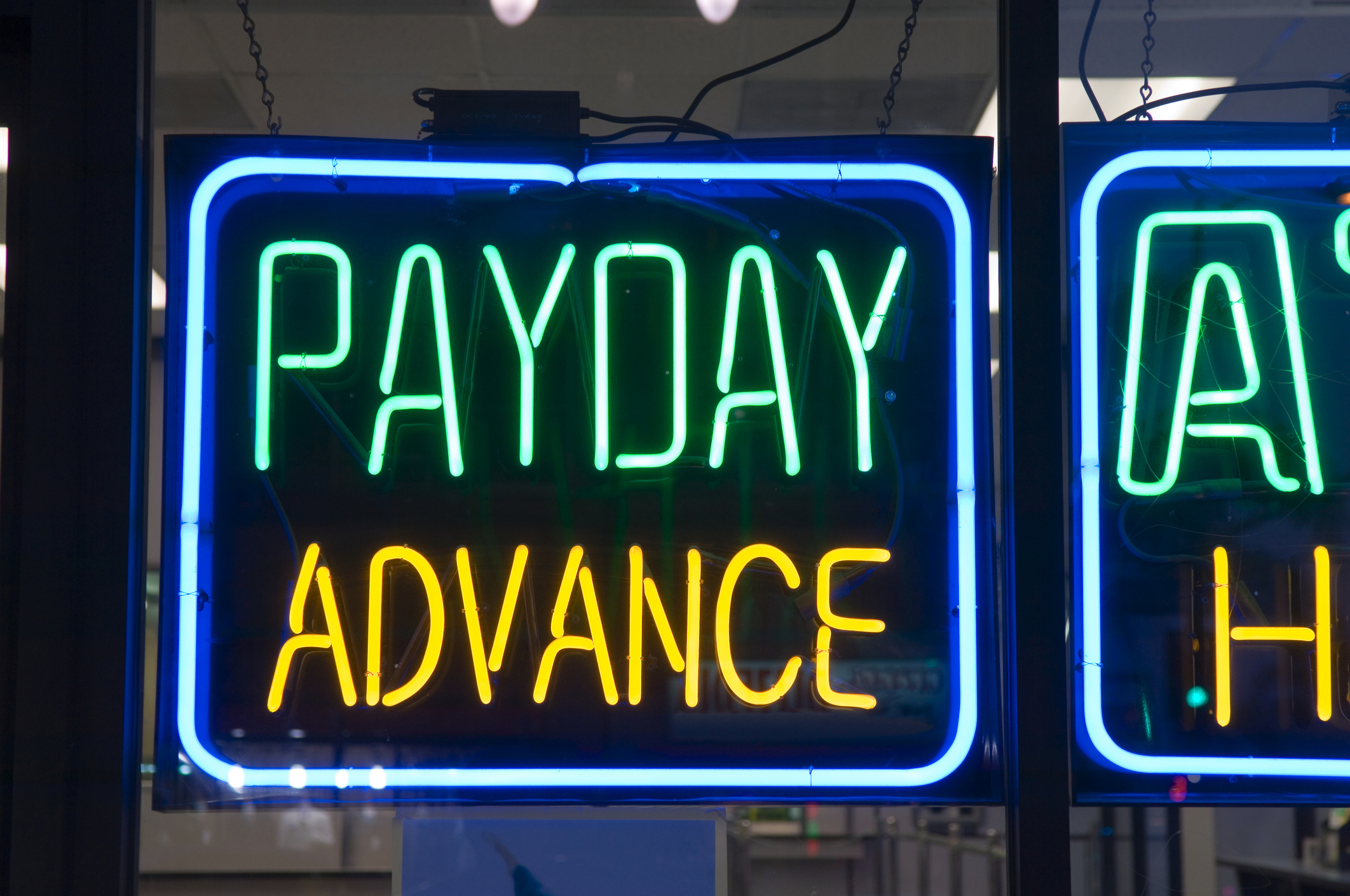 Neon sign in a window displaying the words "PAYDAY ADVANCE"