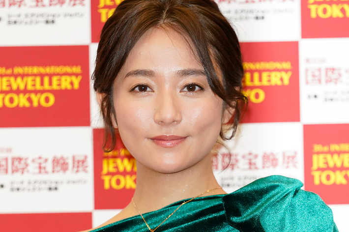 第34回国際宝飾展の広告記事にて、緑色のドレスを着ている女性の肖像写真。