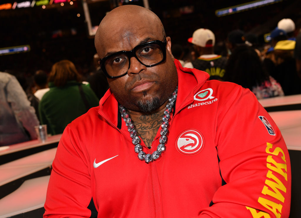 CeeLo Green at an event, wearing a sports jacket with a large necklace and glasses
