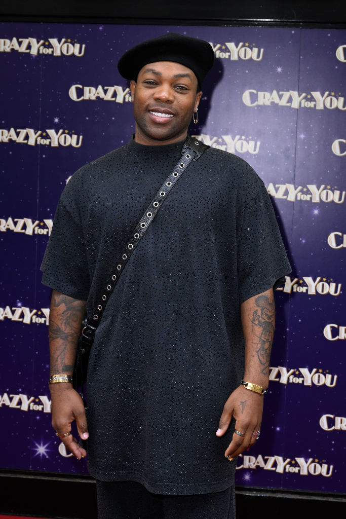 Todrick Hall stands on the red carpet at the "Crazy for You" event, wearing a relaxed, sparkling black outfit and a matching beret