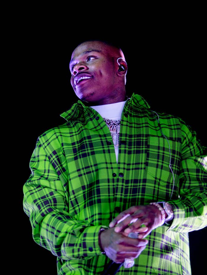 DaBaby performing on stage, wearing a patterned shirt and holding a microphone